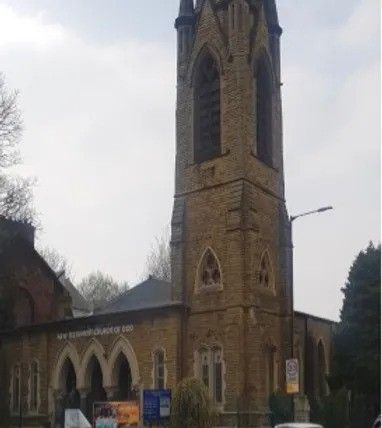 A large church with a bell tower in the middle of a city.