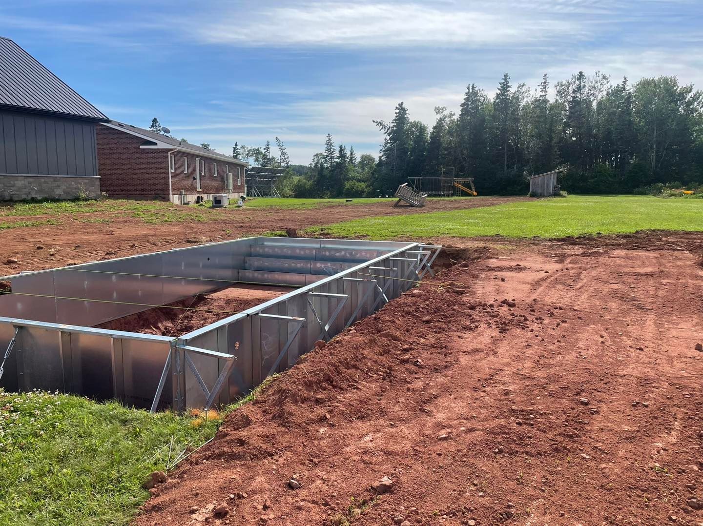 A large metal frame is sitting in the middle of a dirt field.