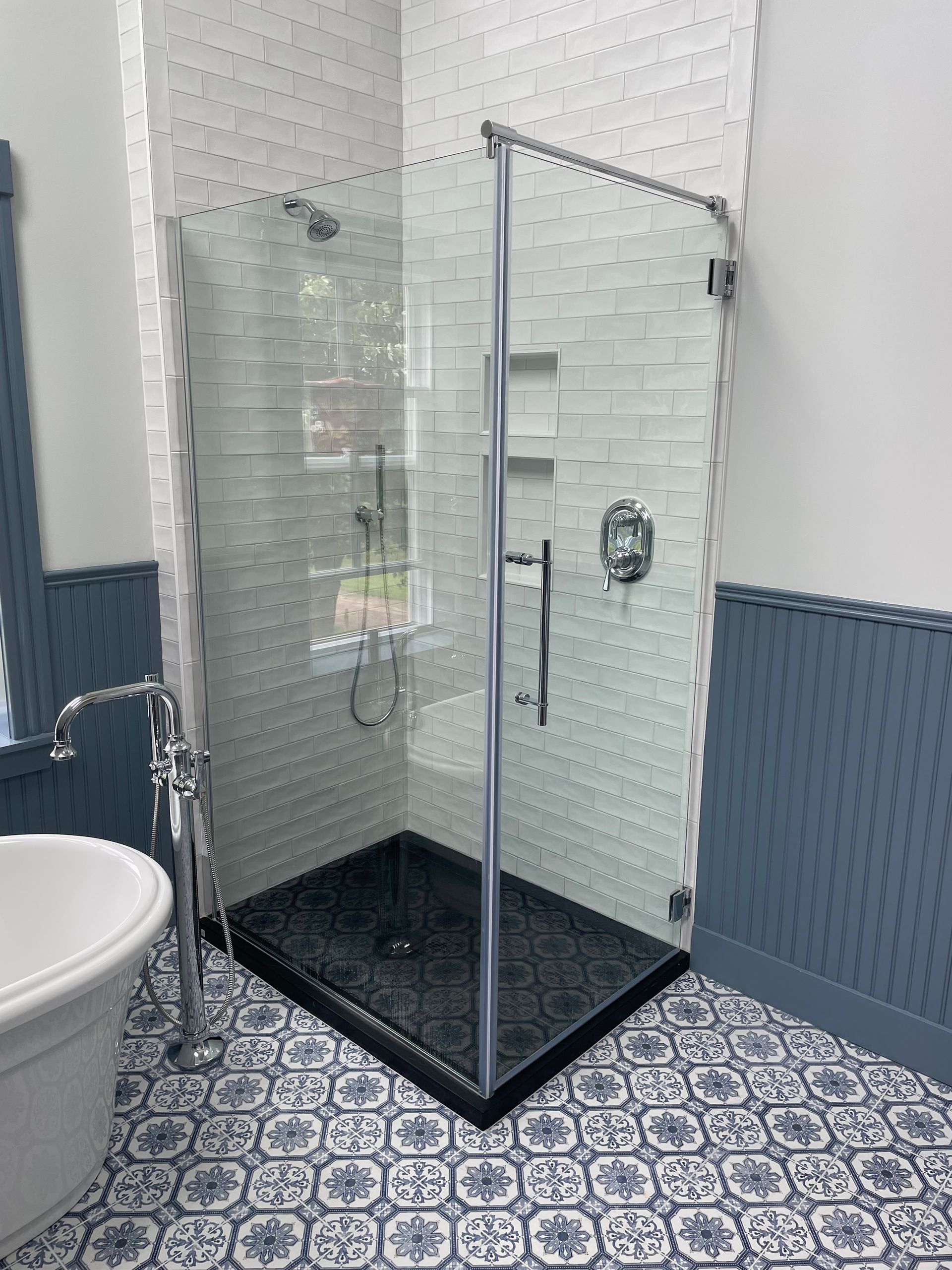 A bathroom with a walk in shower and a bathtub.