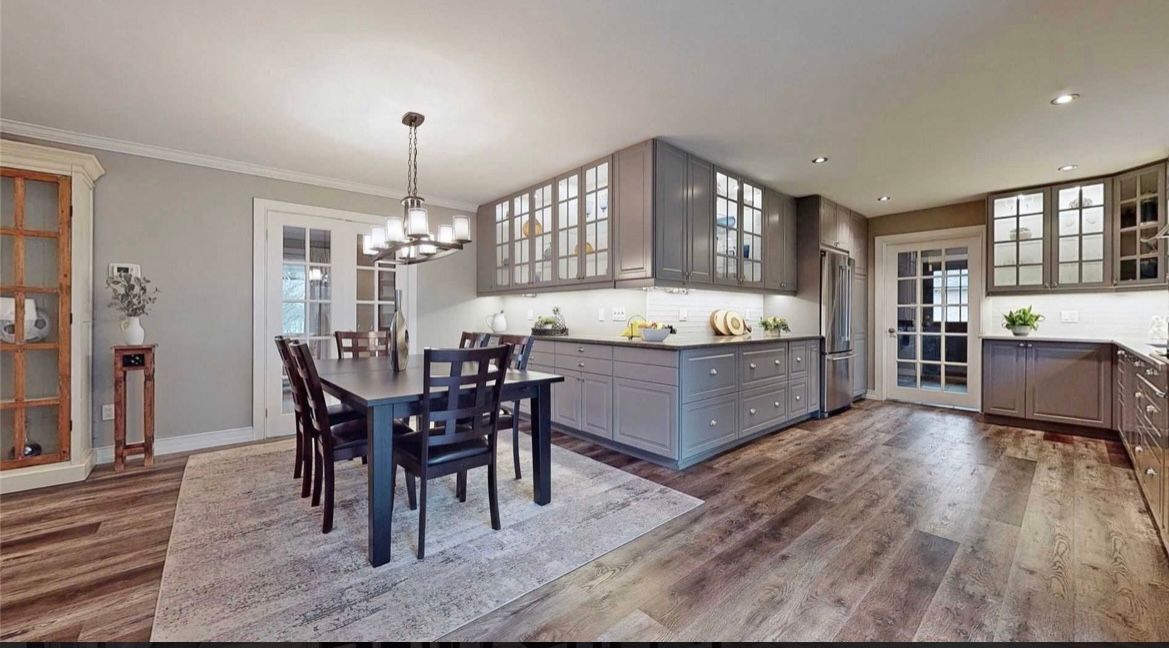 A kitchen and dining room in a house with a table and chairs.