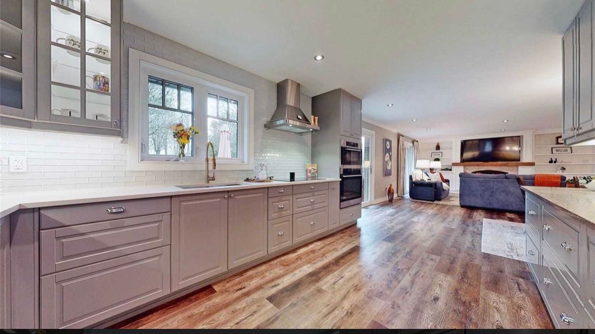 A kitchen with a lot of cabinets and hardwood floors.