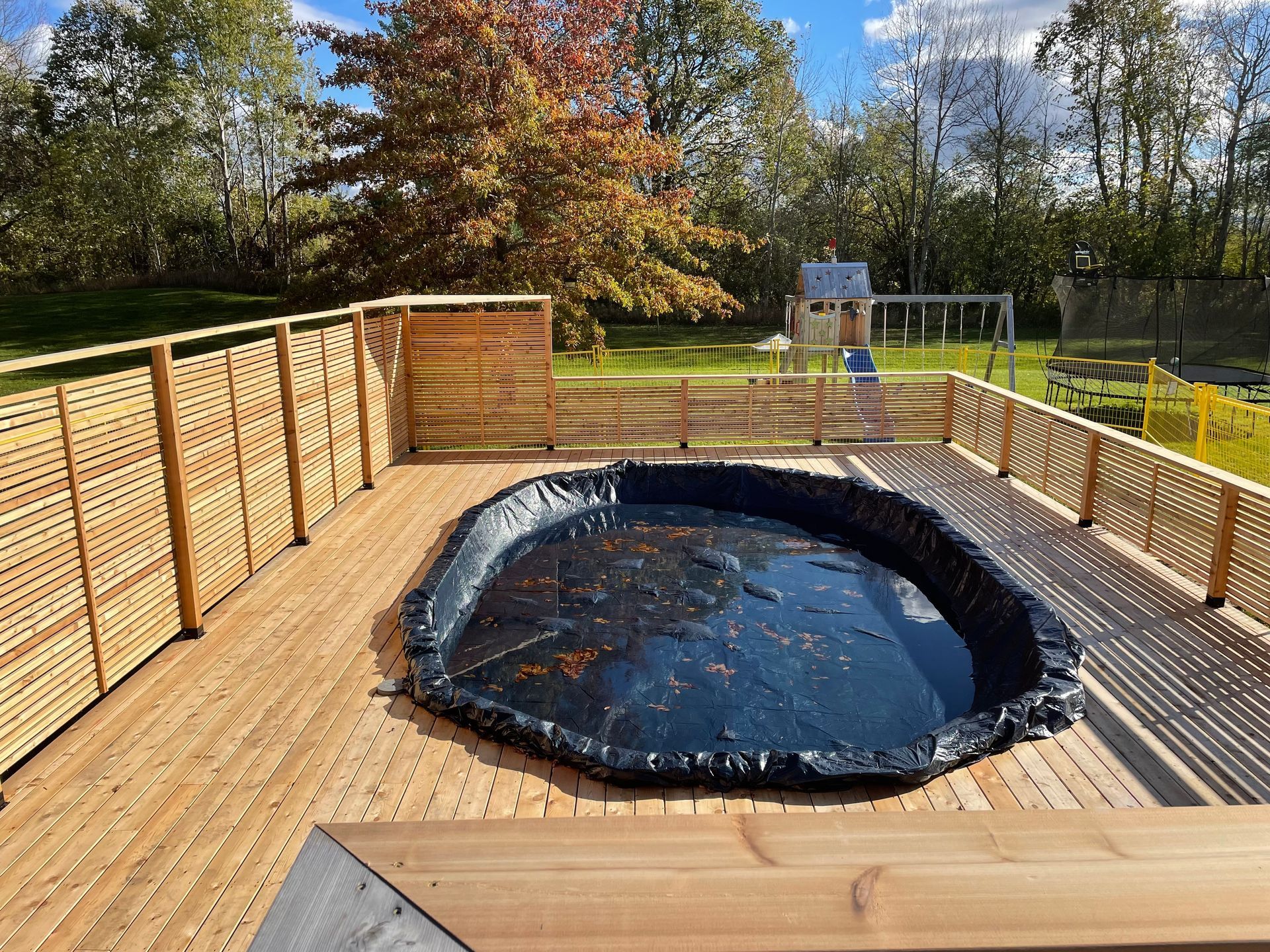 A hot tub is sitting on top of a wooden deck.
