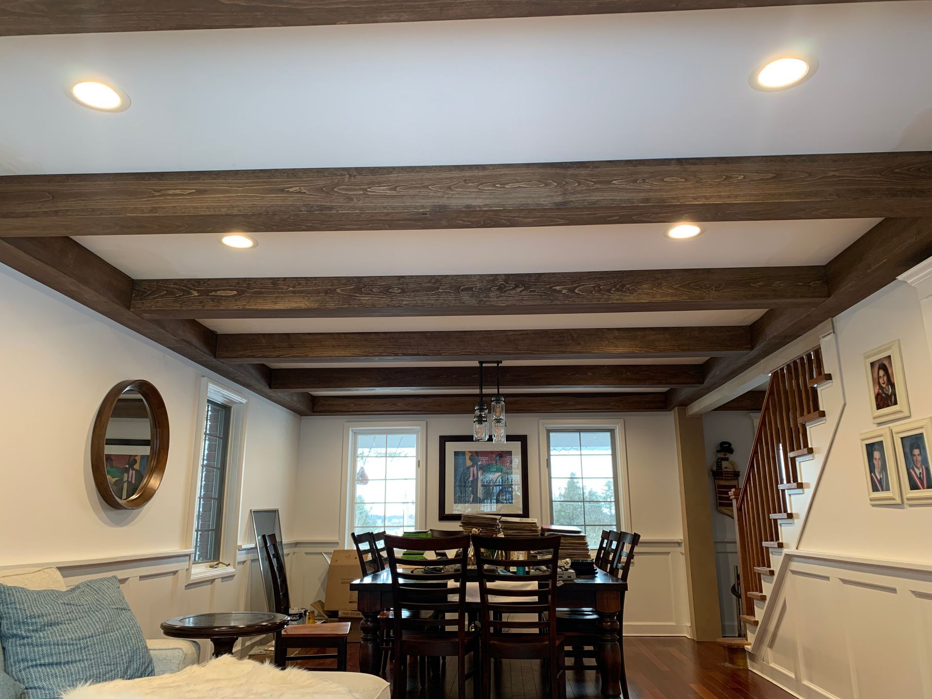 A living room with a dining room table and chairs and a staircase.