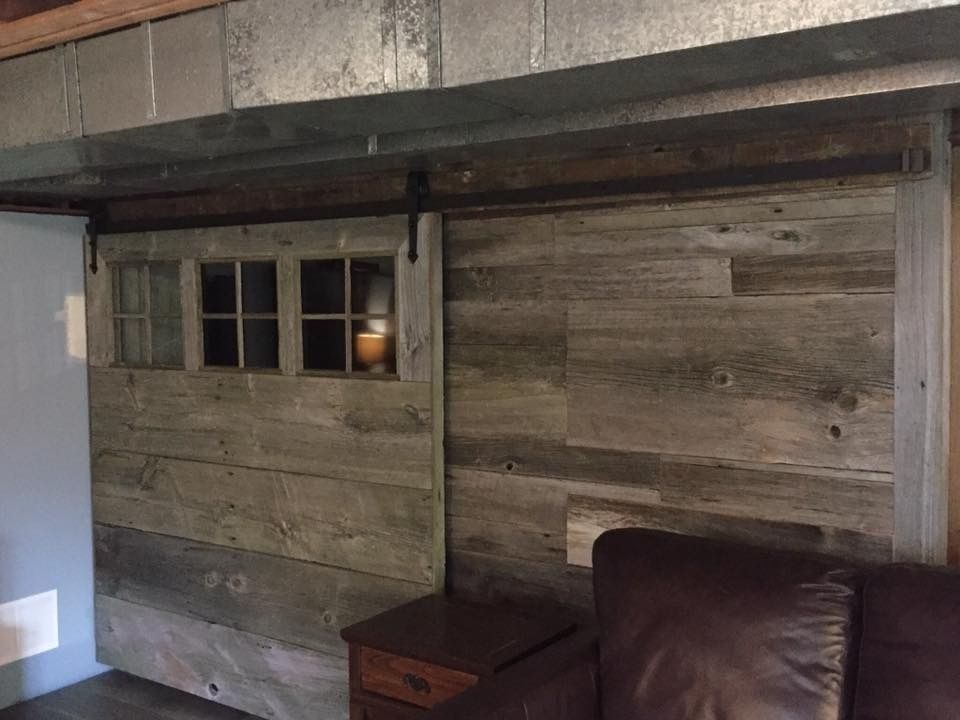 A living room with a wooden wall and a couch.