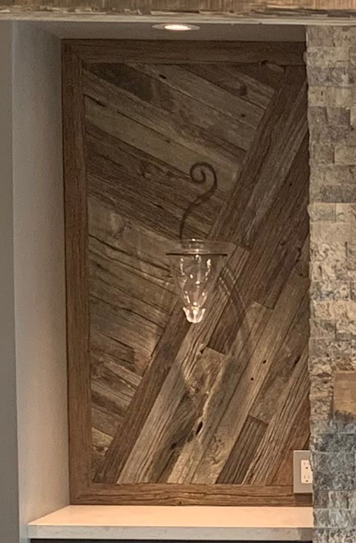 A wooden wall with a candle holder hanging from it.