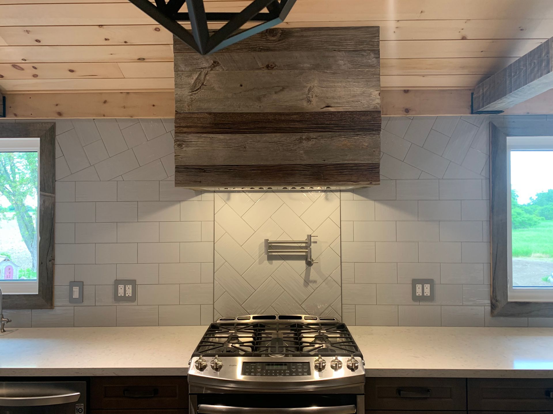 A kitchen with a stove top oven and a wooden hood.