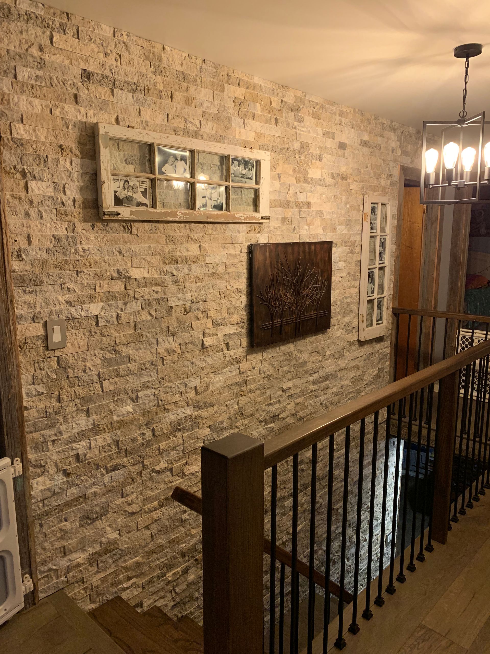 A staircase with a wooden railing and a brick wall.