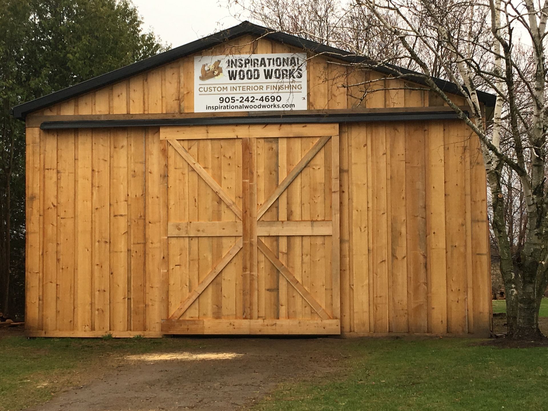A wooden barn with a sign that says inspirational wood works