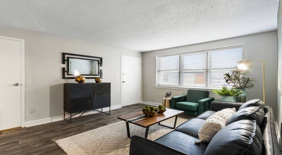 Living room with dark wood floors, gray walls, black cabinet, and green armchair.