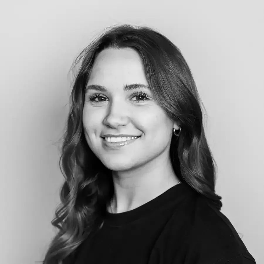 Man wearing a baseball cap and polo shirt, smiling at the camera in a studio.
