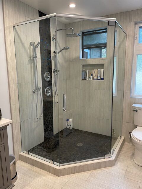 A bathroom with a walk in shower and a toilet.