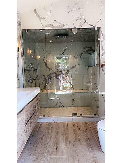 A bathroom with a walk in shower and a toilet.