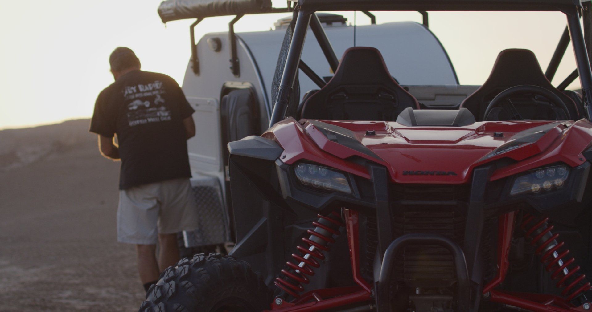 man next to white off-road camping trailer