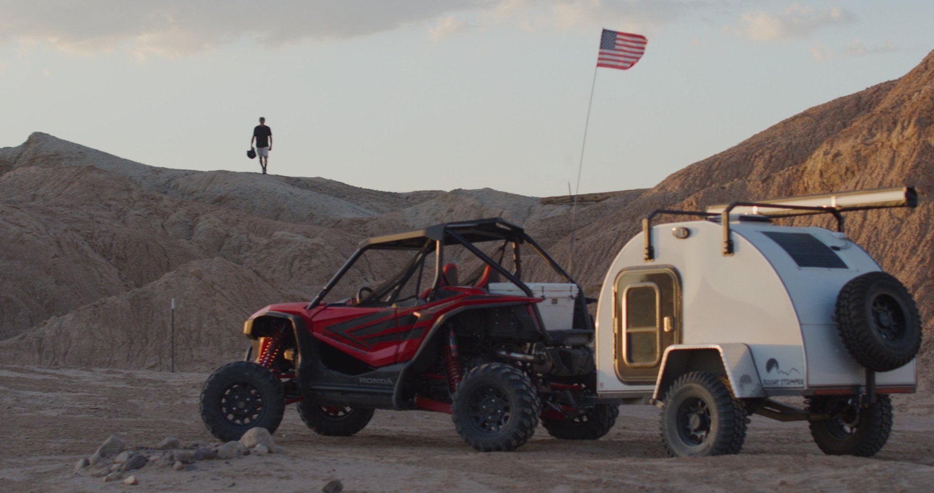 red UTV and white off-road trailer parked