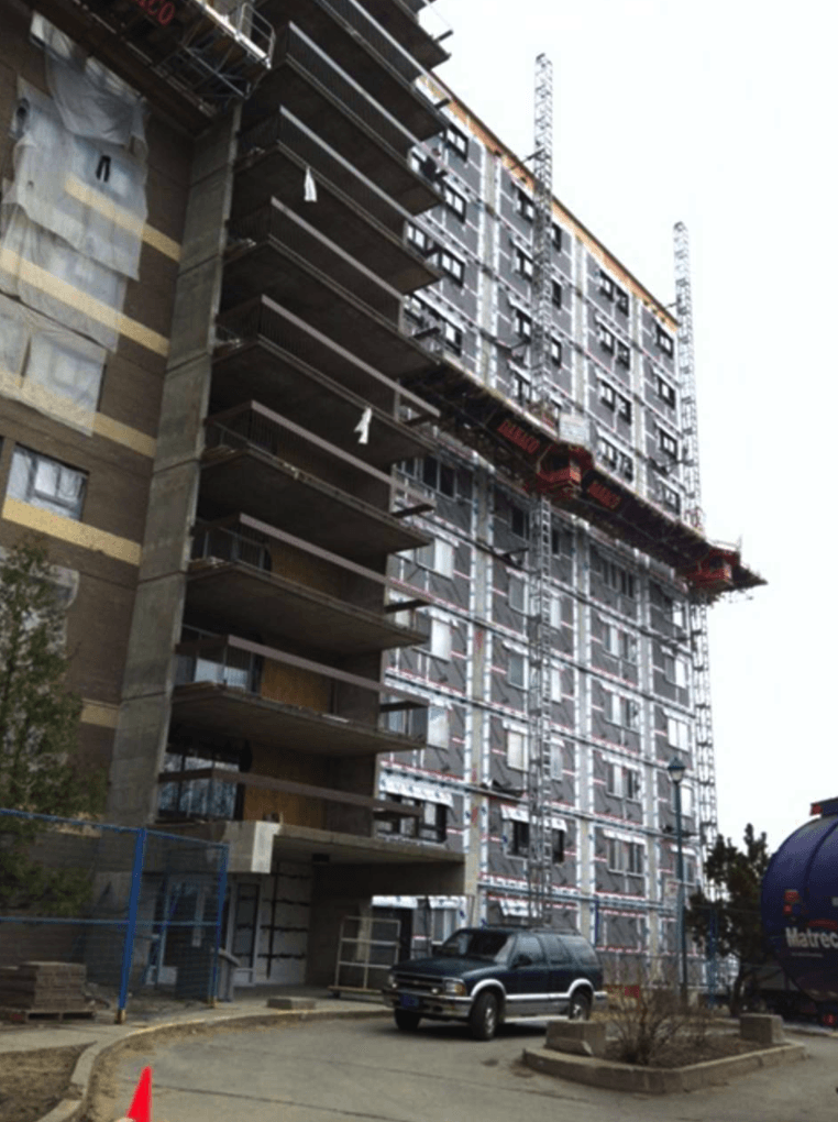 A car is parked in front of a building under construction