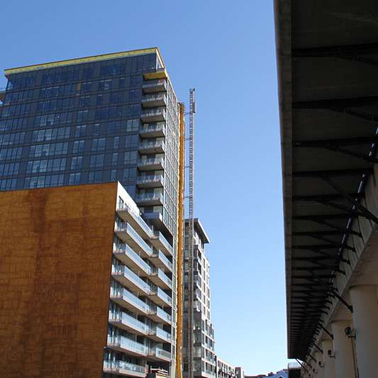 A tall building with a yellow crane on top of it