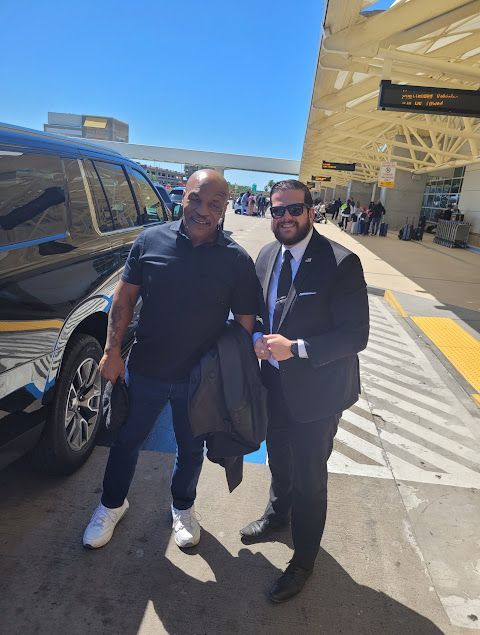 Tipper chauffeur greeting guests at airport