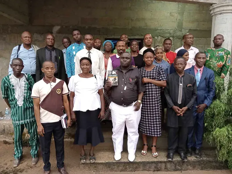 A group of people standing together in a formal line outdoors in front of a building for a portrait.