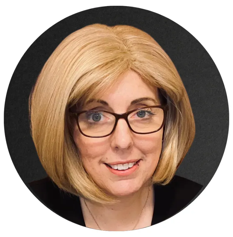 Woman with short, blonde hair and glasses, smiling. Black background.