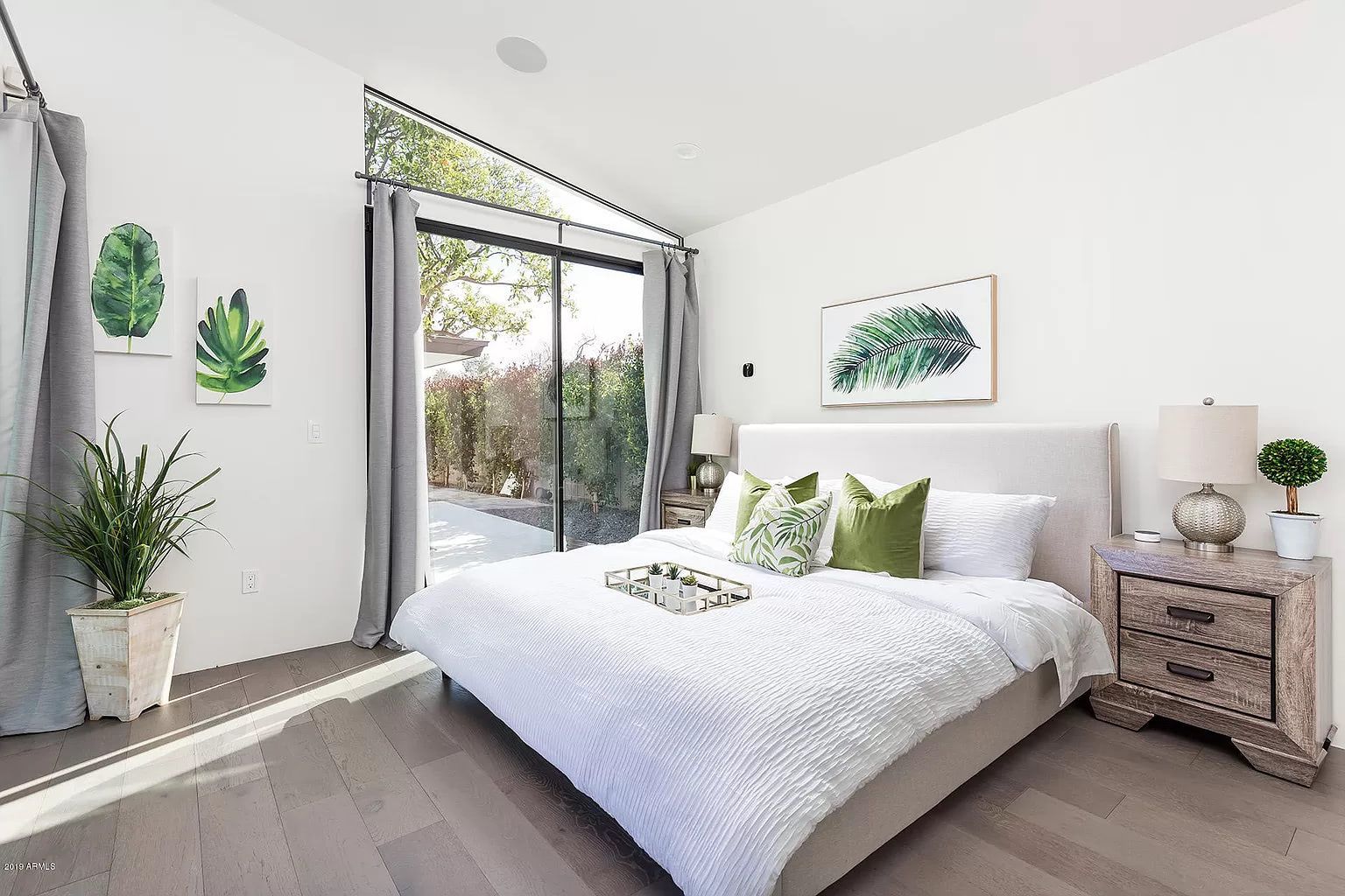 A bedroom with a large bed and a sliding glass door.