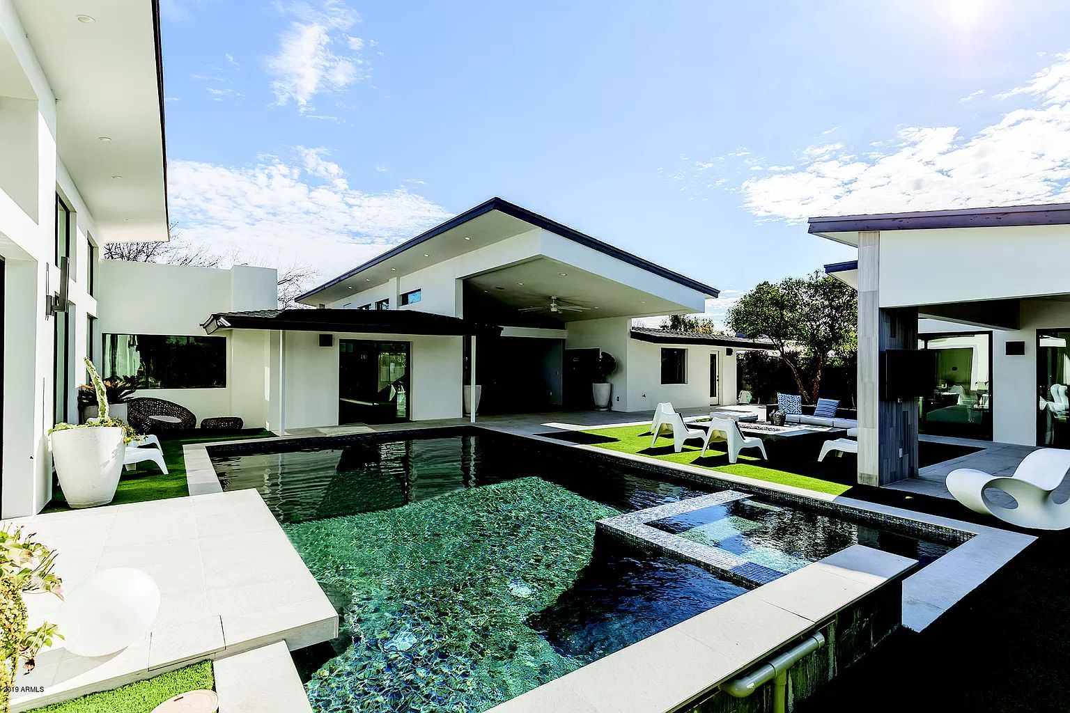 A large white house with a large swimming pool in the backyard.