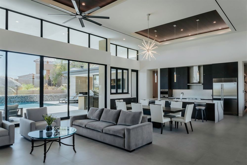 A living room with a couch and chairs and a ceiling fan