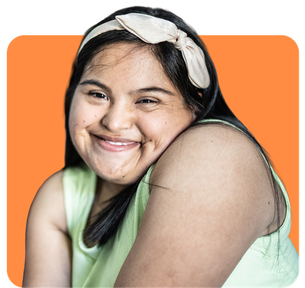 Woman with Down syndrome smiling, wearing a headband, orange background.