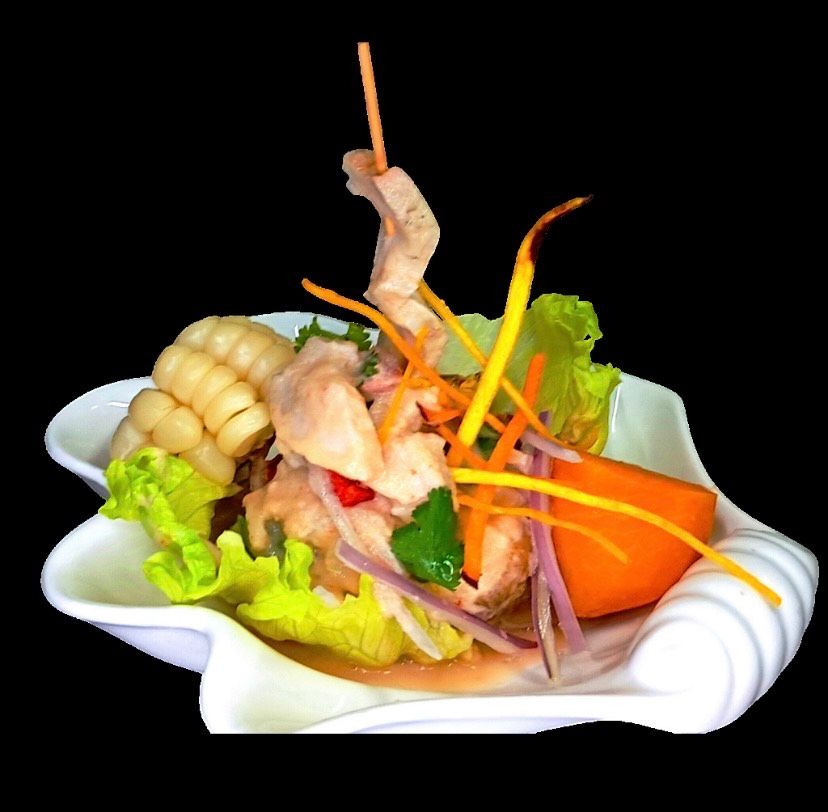 Un recipiente blanco lleno de verduras y carne sobre un fondo negro.