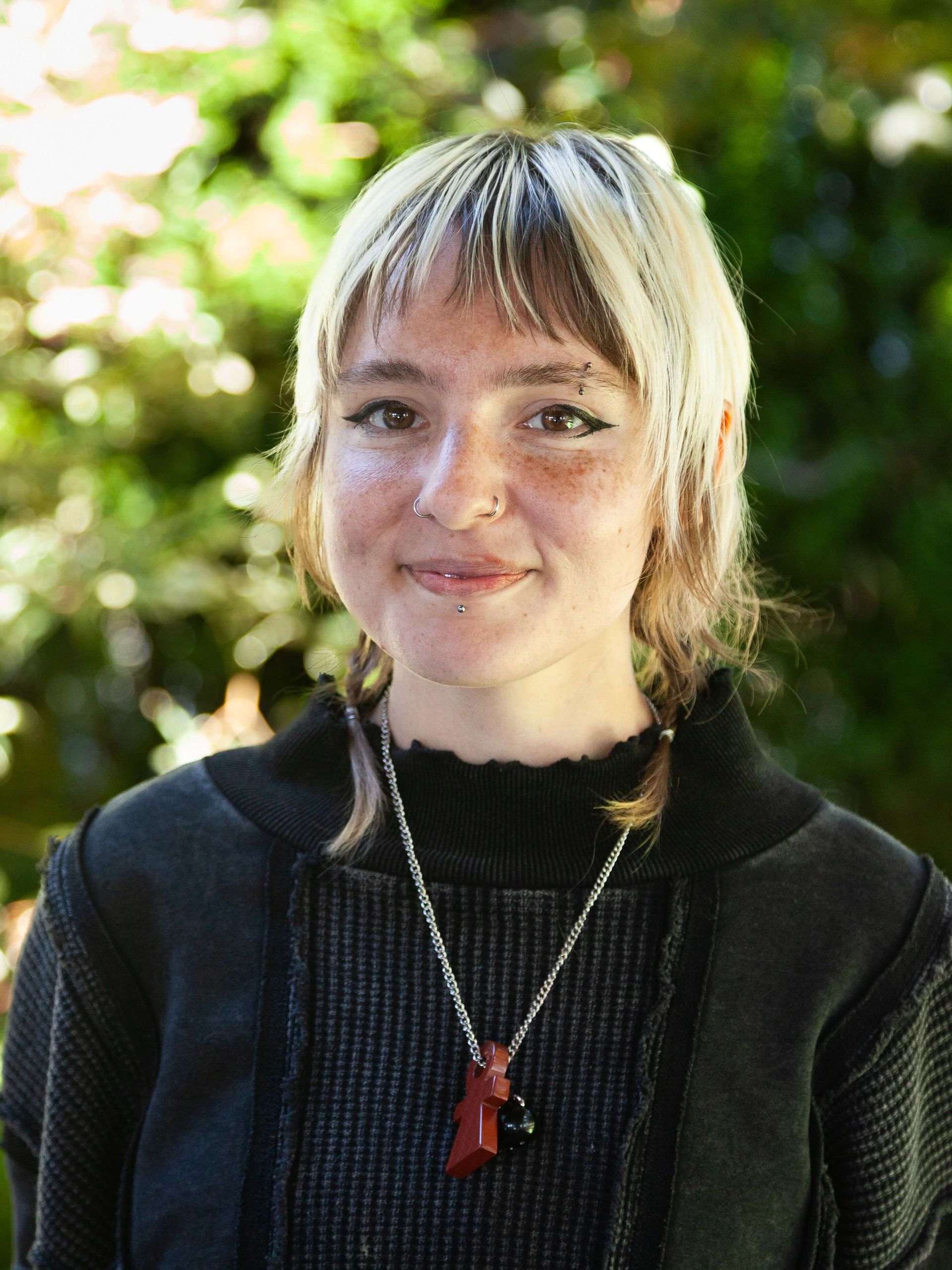 Woman smiling with short blonde and brown hair.