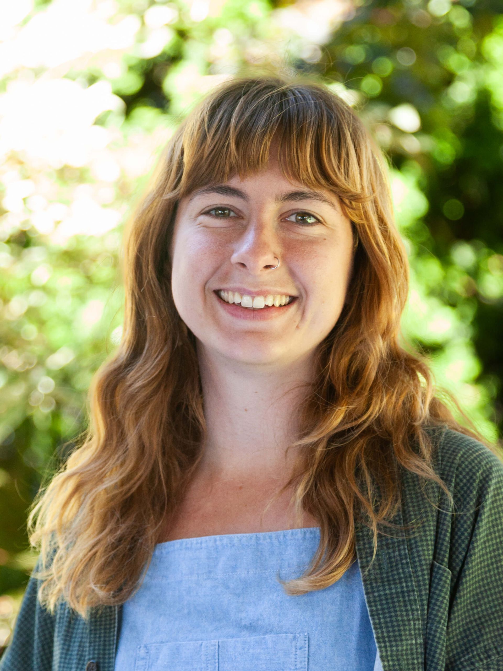 Woman with wavy auburn hair smiling.