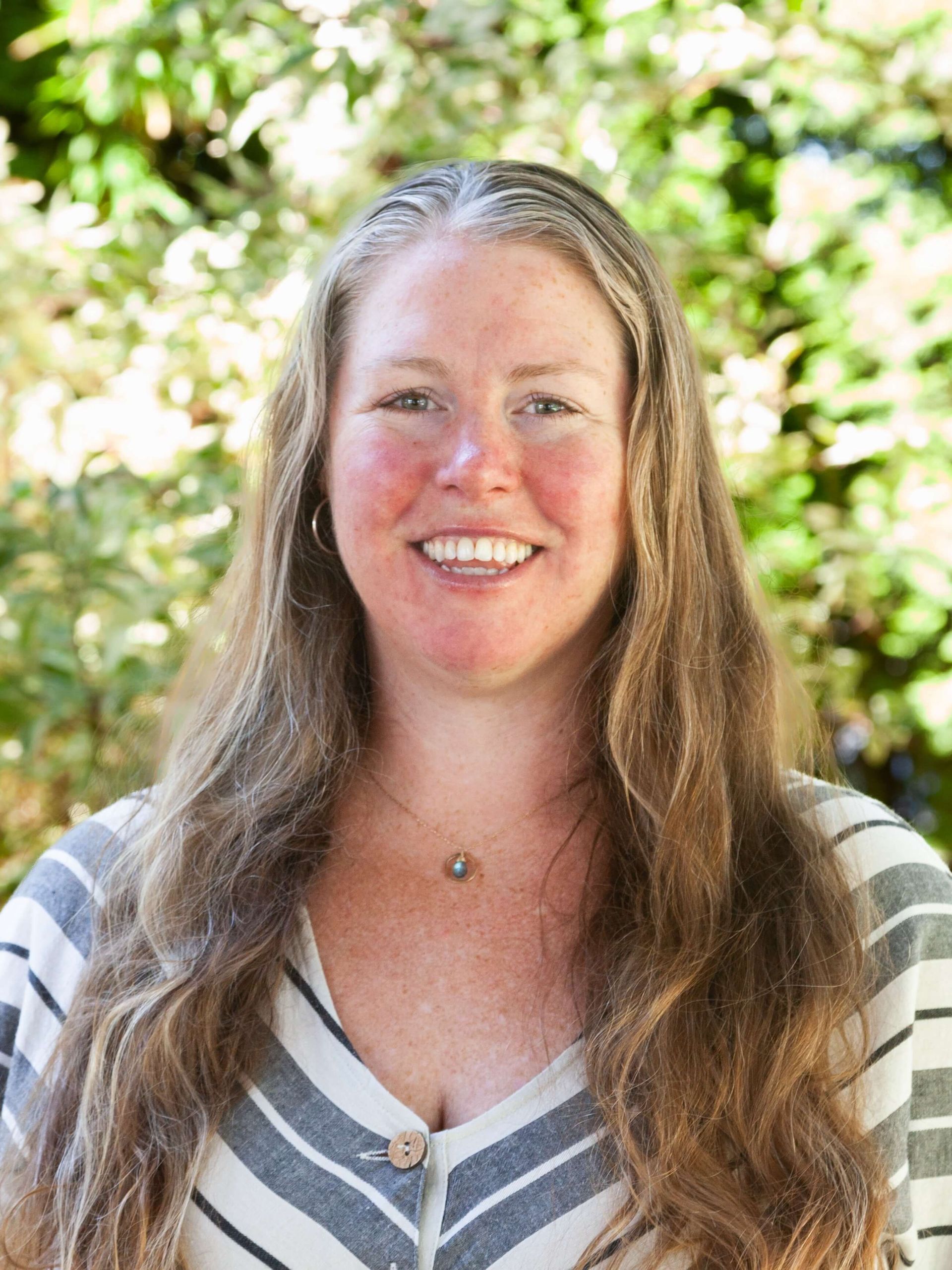 Woman in striped dress smiling.