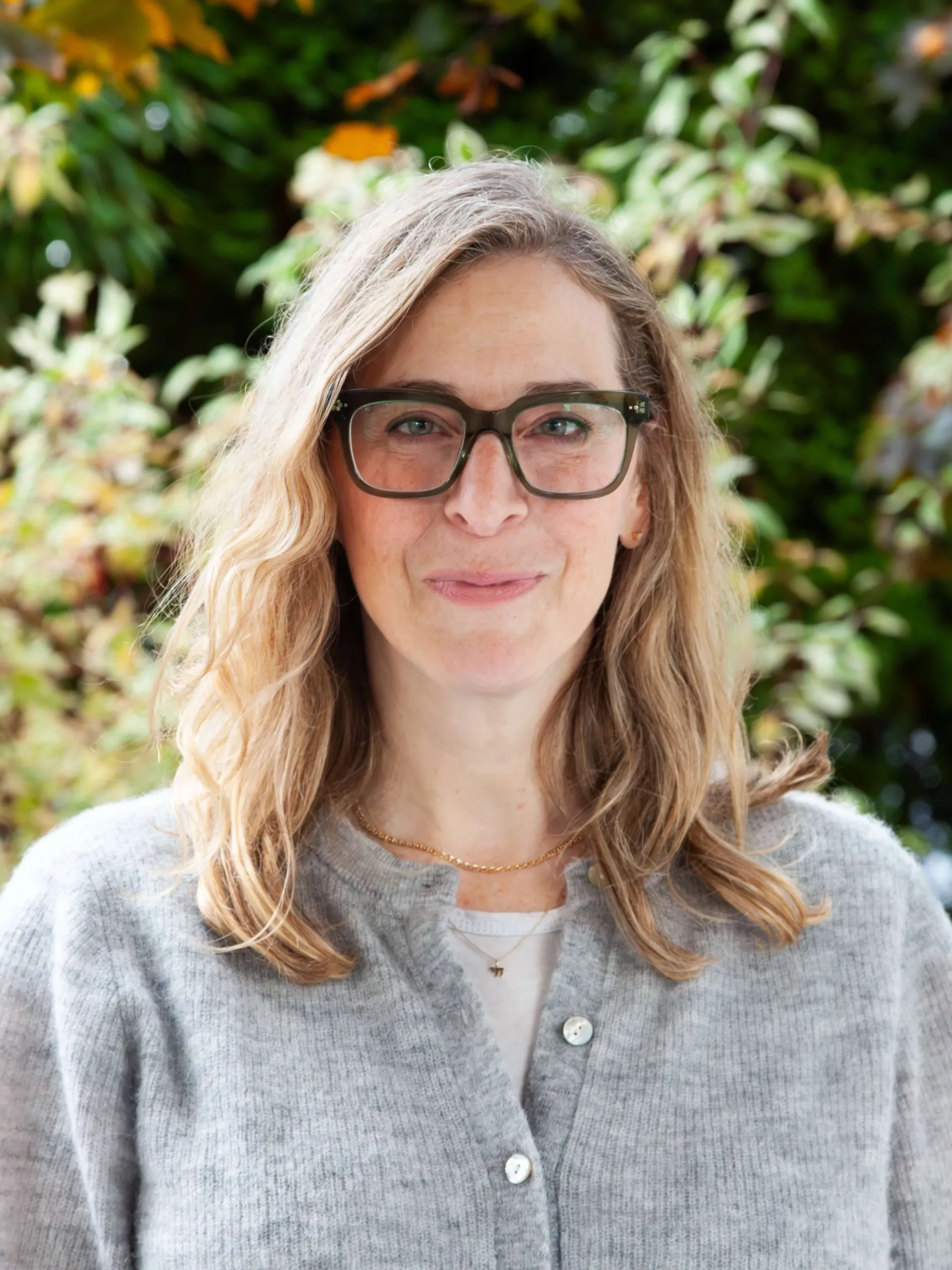 Woman wearing glasses and a grey sweater.