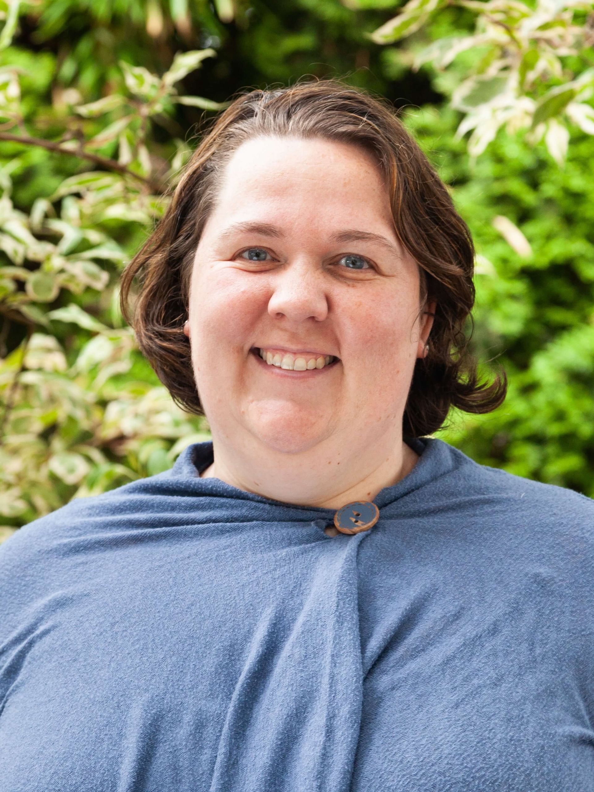 Woman with short brown hair smiling. 