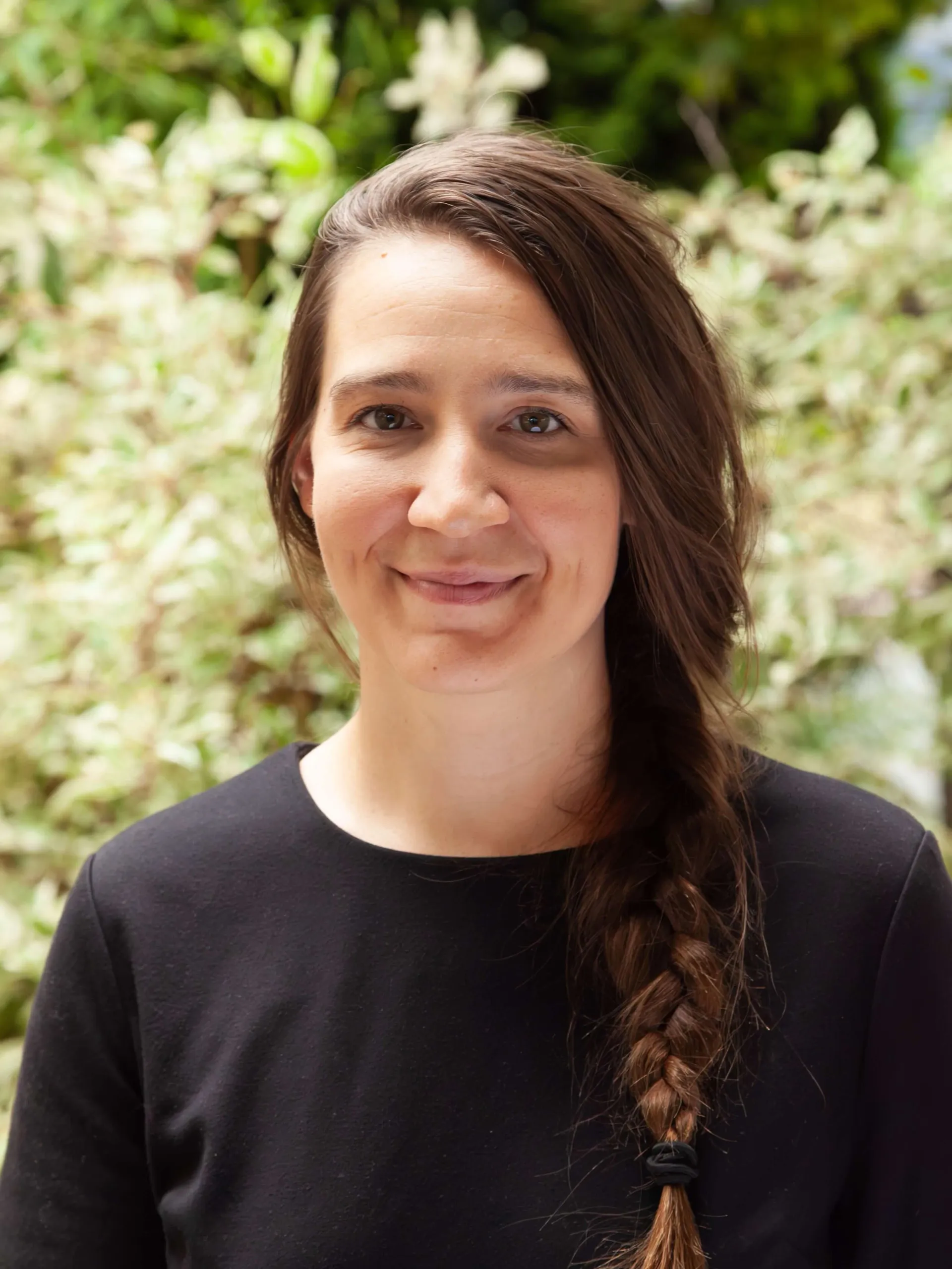 Woman smiling with long straight brown hair.