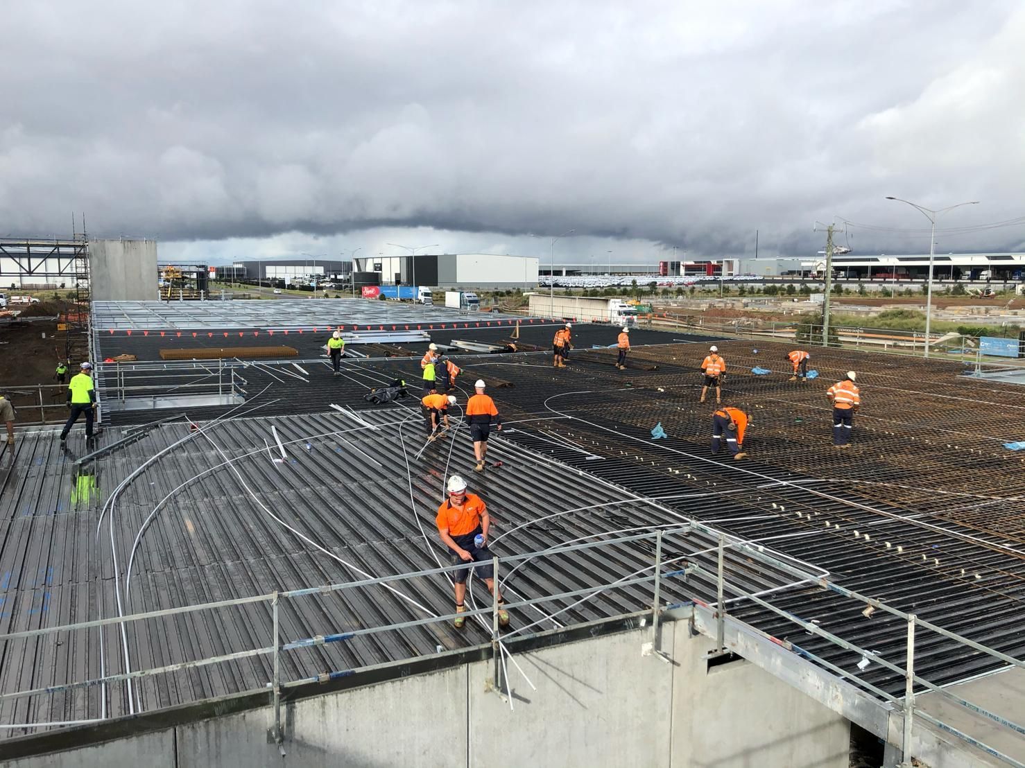 A group of construction workers are working on a concrete floor.