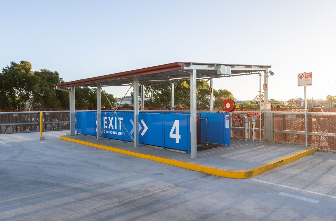 A blue container with the number 4 on it is in a parking lot.