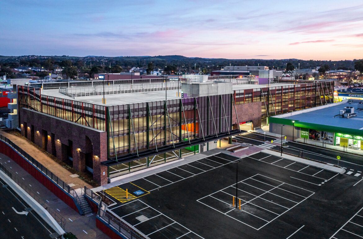 An aerial view of a parking lot in front of a large building.