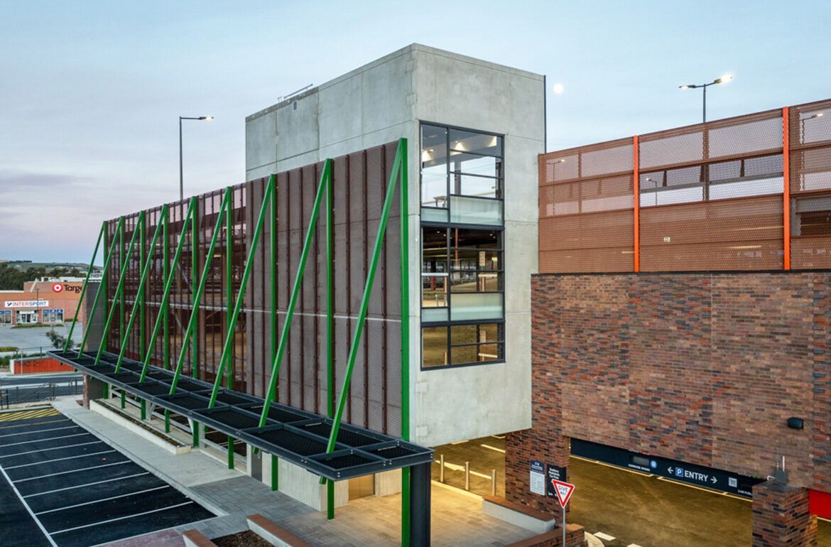 A large building with a lot of windows and a parking lot in front of it.