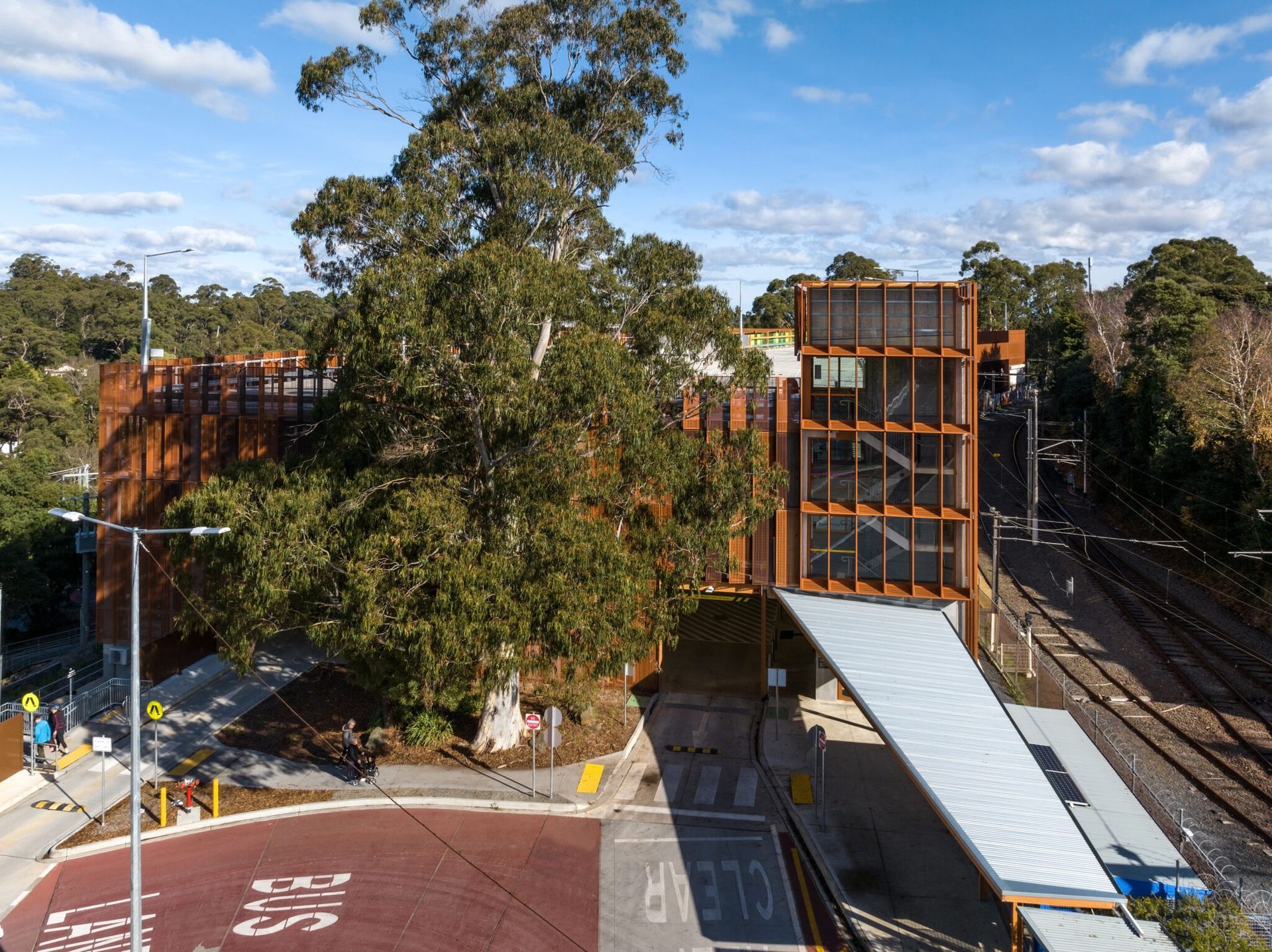An aerial view of a train station with a bridge over the tracks.