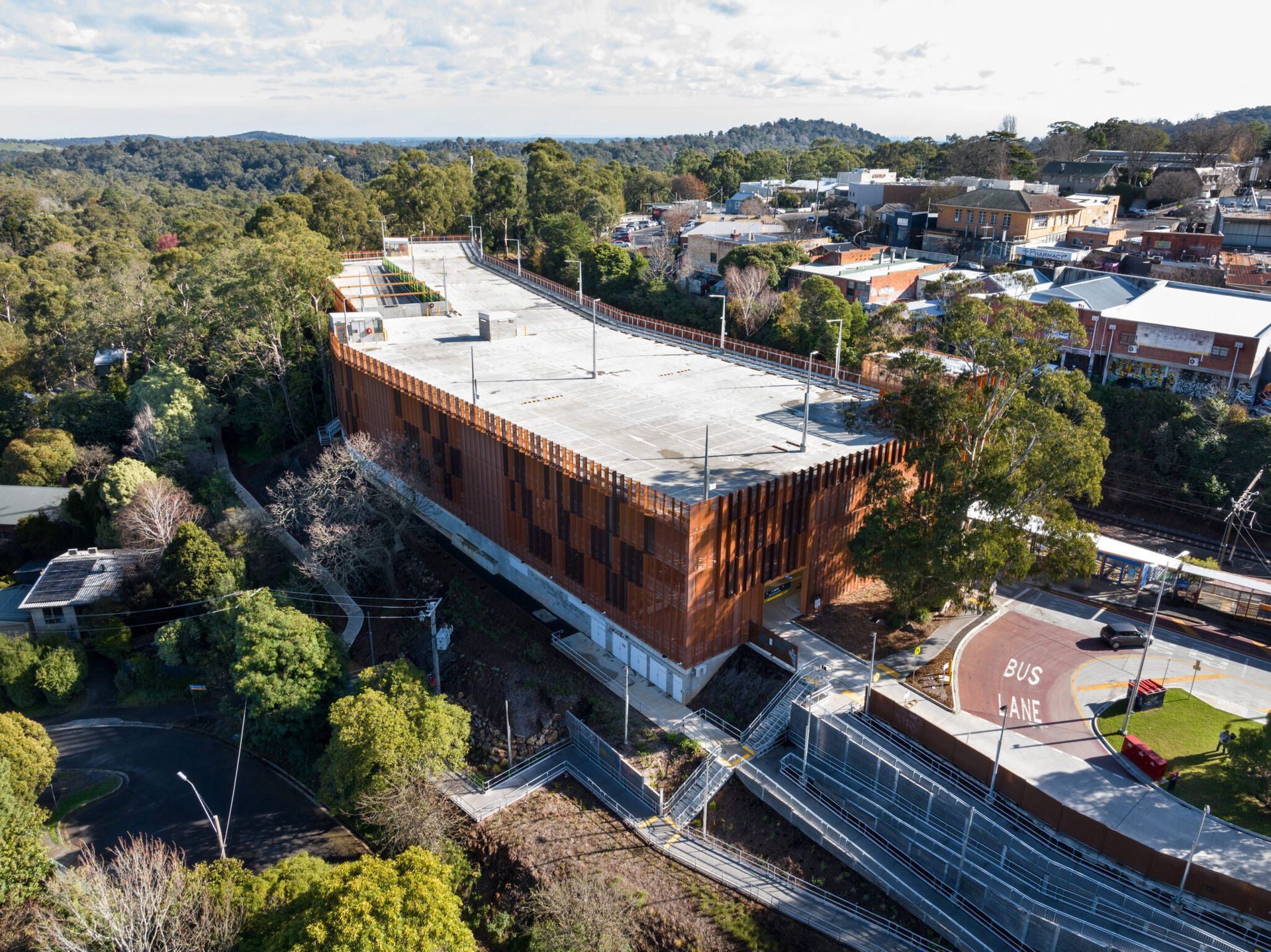 An aerial view of a large building surrounded by trees in a city.