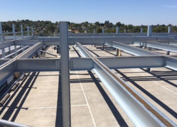 A large metal structure is being built on the roof of a building