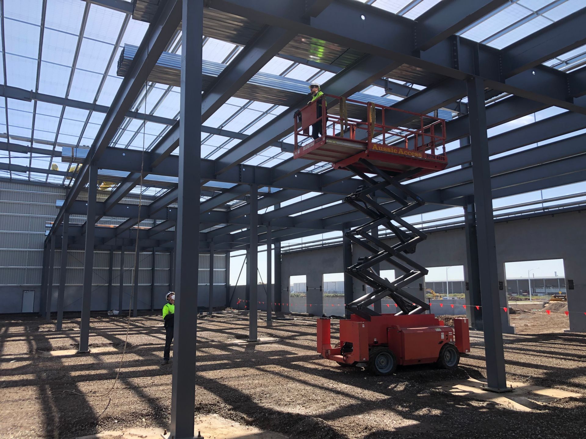 A construction site with a scissor lift in the middle of it.