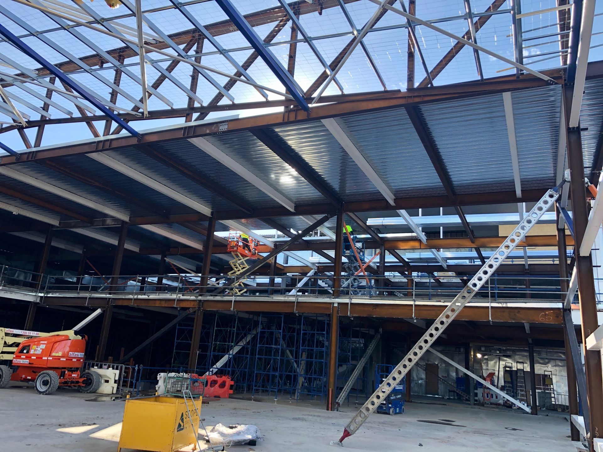 A large building under construction with a ladder in the middle of it with generator.