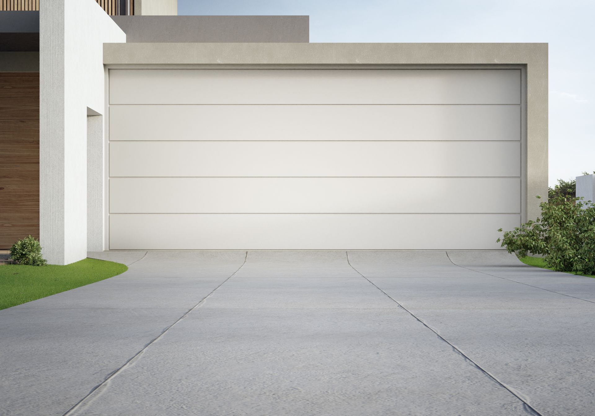 Exterior view of a modern house with a closed, light-colored garage door and a gray concrete driveway.
