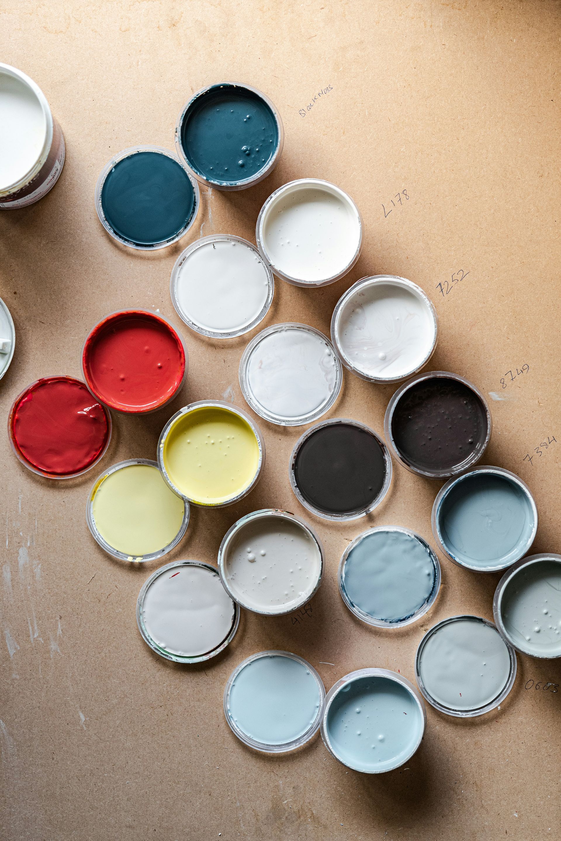 A bunch of paint cans are lined up in a circle on the floor