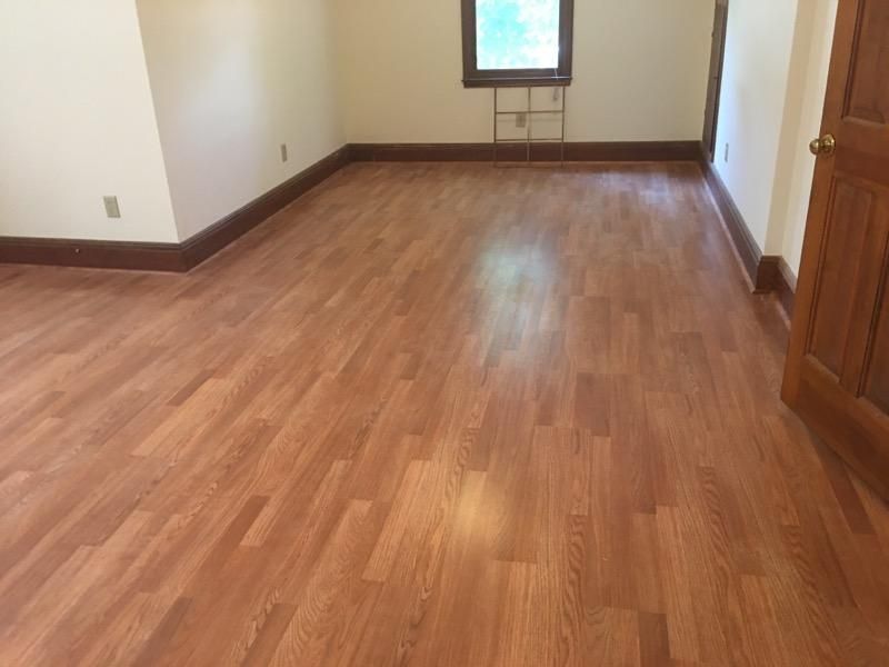 An empty room with hardwood floors and a window.