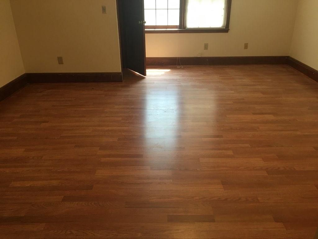 An empty room with a wooden floor and a window.