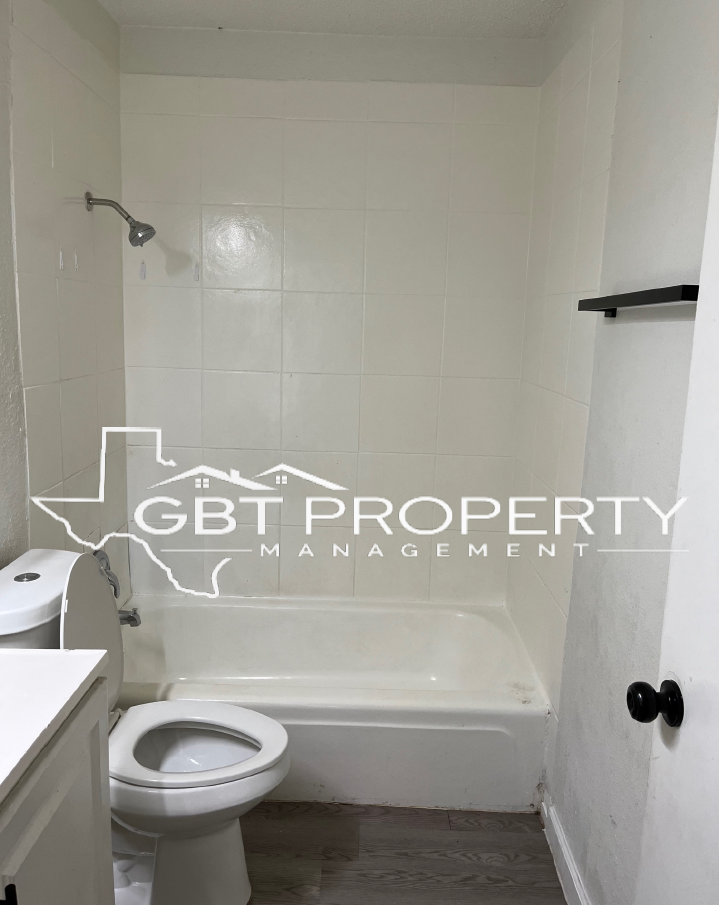 A bathroom with a toilet , bathtub and shower.