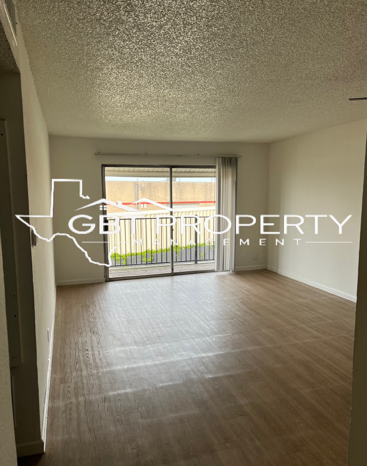A living room with hardwood floors and a sliding glass door.