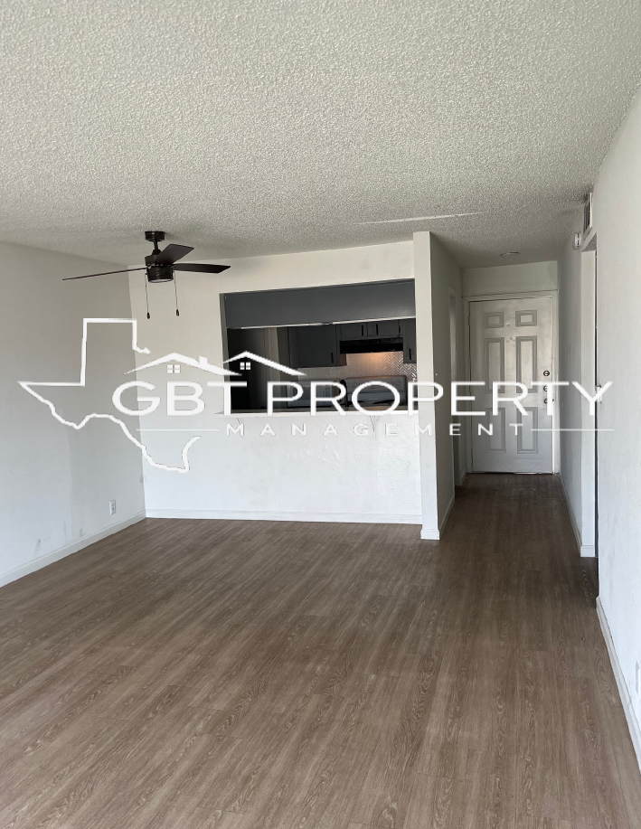A living room with hardwood floors and a ceiling fan.